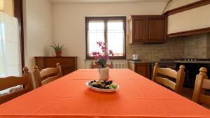 a kitchen with a table with a bowl of fruit on it at La Casa di Ekeko in Vivaro