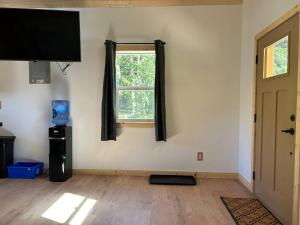 a living room with a flat screen tv and a window at Mountains Edge Bungalow in Sayward