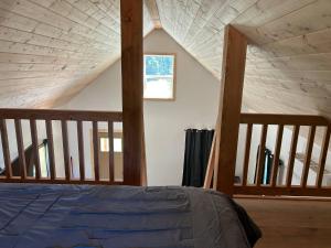 a attic bedroom with a bed and a window at Mountains Edge Bungalow in Sayward