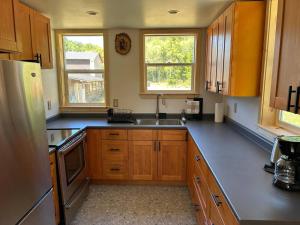 a kitchen with wooden cabinets and a sink at Mountains Edge Bungalow in Sayward