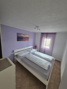 a bedroom with a bed in a room with a window at Apartmani Mia in Karlobag