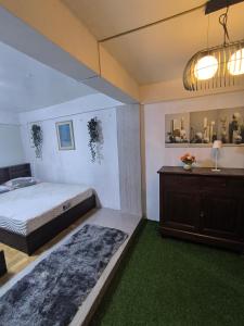a bedroom with a bed and a dresser and a mirror at Tagaytay Resthouse 3 big rooms in Ulot