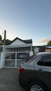 a car parked in front of a white gate at Tagaytay Resthouse 3 big rooms in Ulot +34 photos
