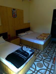 two beds sitting in a room with a floor at Dev Niwas in Nākuri +2 photos