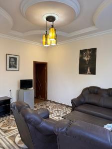 a living room with a leather couch and a chandelier at Msho Amroc in Aparan