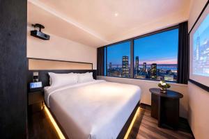 a hotel room with a bed and a large window at Skyline Grand International Hotel - Prime Tianhe City Center Walkable Subway Top Pick for Canton Fair Stunning High Floor Panoramic City View Luxury Guest Rooms in Guangzhou