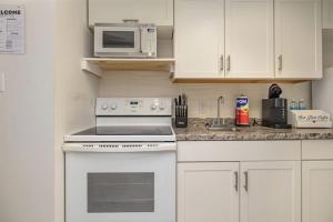a kitchen with a white stove and a microwave at Spacious Beach Condo Double Suite for Couples Getaway in Myrtle Beach