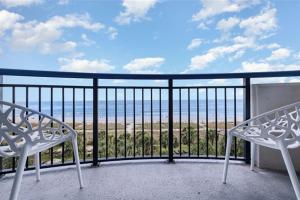 a balcony with two white chairs and a view of the ocean at Spacious Beach Condo Double Suite for Couples Getaway in Myrtle Beach