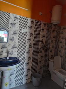 a bathroom with a toilet and a sink in it at Dev Niwas in Nākuri