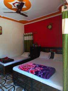 two beds in a room with red walls at Dev Niwas in Nākuri
