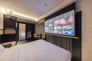a hotel room with a large screen on the wall at Skyline Grand International Hotel - Prime Tianhe City Center Walkable Subway Top Pick for Canton Fair Stunning High Floor Panoramic City View Luxury Guest Rooms in Guangzhou