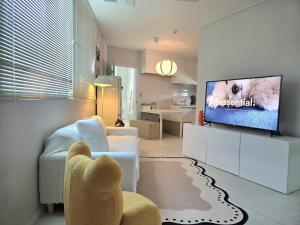 a living room with a couch and a tv at SlowNight, Suwon in Suwon