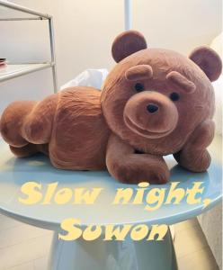 a brown teddy bear sitting on top of a sign at SlowNight, Suwon in Suwon