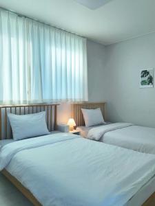 two beds sitting next to each other in a bedroom at SlowNight, Suwon in Suwon +19 photos
