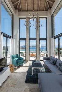 a living room with a couch and chairs and windows at Seacrete villas in Chania