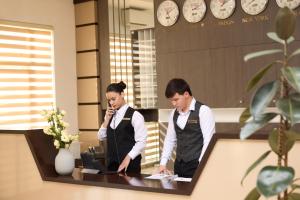 two people standing at a desk in an office at Чынар Отель in Änew