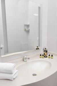 a bathroom sink with a large mirror and white towels at Чынар Отель in Änew +63 photos