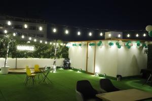 a patio with chairs and lights at night at Grenelle-Indirapuram in Ghaziabad