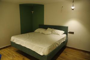 a bedroom with a bed with a green wall at Grenelle-Indirapuram in Ghaziabad
