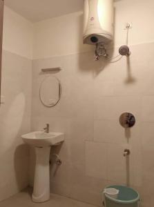 a bathroom with a sink and a mirror and a toilet at Hangout at Nandi Hills in Nandigunda
