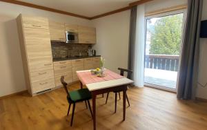 a small kitchen with a table and a dining room at Pension Max Schraml in Grundlsee +26 photos