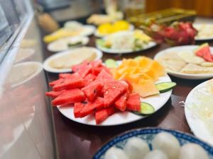 a table topped with plates of fruits and vegetables at Brotherhood Loop Hostel Station in Làng Lap +7 photos