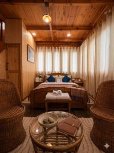 a bedroom with a bed and two chairs and a table at The Shivdhaar Estate kud'Patnitop in Kūd