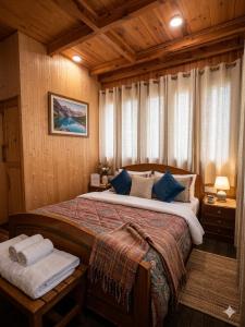 a bedroom with a large bed with blue pillows at The Shivdhaar Estate kud'Patnitop in Kūd +49 photos
