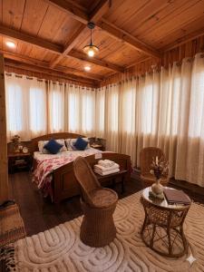 a bedroom with a bed and two chairs and a table at The Shivdhaar Estate kud'Patnitop in Kūd