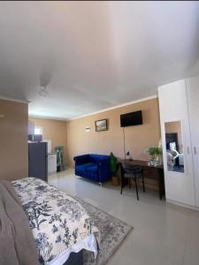 a bedroom with a blue bed and a desk at Zambata Self Catering in Gqeberha