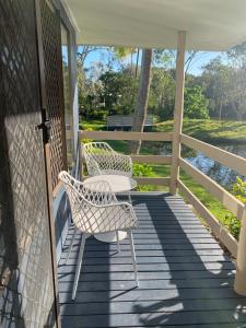 two chairs and a table on a porch at Turtle Cove Lake Front Cabin 300m To Beach in Hervey Bay +20 photos