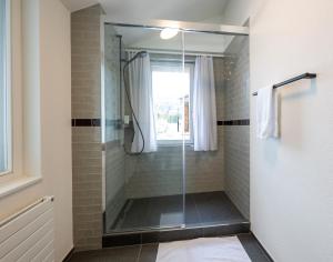 a shower with a glass door in a bathroom at 5 room apartment for 8 people at Bergcafe Aurora Lenzerheide in Lenzerheide +17 photos