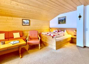 a bedroom with a bed and a table and a chair at Landhaus Spielmannsau in Oberstdorf