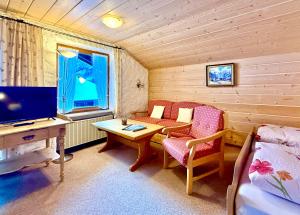 a room with a desk and a tv and a table at Landhaus Spielmannsau in Oberstdorf