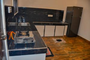 a kitchen with a stove and a refrigerator at Vishu villa in Galle