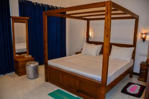 a bedroom with a canopy bed and a mirror at Vishu villa in Galle