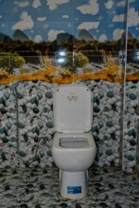 a toilet in a bathroom with a rock wall at Vishu villa in Galle