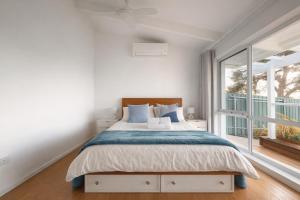 a bedroom with a bed and a large window at Oceanview Sunset Villa Hallett Cove 3BR 2Bath Large Deck Free Parking in Halletts Cove +20 photos