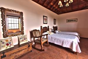 1 dormitorio con 2 camas y espejo en Casa Rural Hermana "by henrypole home", en Breña