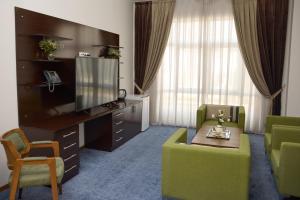 a living room with a tv and a couch and a table at Чынар Отель in Änew
