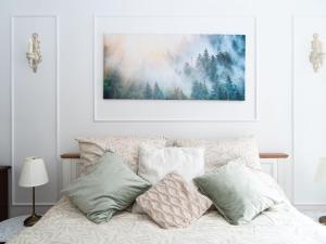 a bedroom with a bed with pillows and a painting on the wall at Altstadt Geverdes 2 in Lübeck