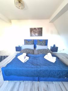 a bedroom with a blue bed with two towels on it at Nordlandgiebel in Rosengarten