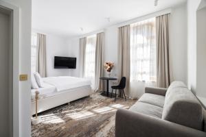 a bedroom with a bed and a couch and a table at Hiša F5 in Ljubljana
