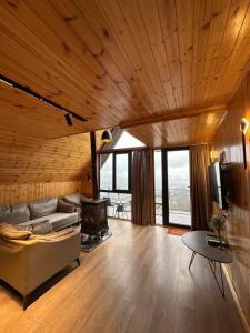 a large living room with a couch and a stove at SilenT Hill Cottage in Gant'iadi
