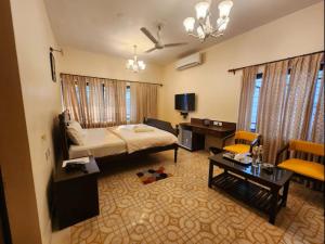 a bedroom with a bed and a living room at Lukochurri in Shānti Niketan