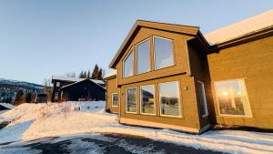 a house with snow on the ground next to a building at Intersporthytta Sogndal in Sogndal