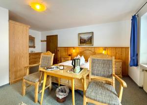 a bedroom with a table and chairs and a bed at Landhaus Spielmannsau in Oberstdorf