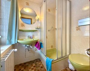 a bathroom with a sink and a toilet and a shower at Landhaus Spielmannsau in Oberstdorf +99 photos