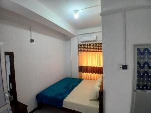 a small bedroom with a bed and a window at AMM Rooms in Nikawatawana