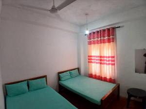 a room with two beds and a window at AMM Rooms in Nikawatawana